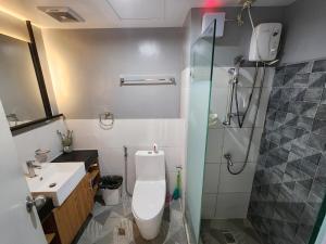 a bathroom with a toilet and a sink and a shower at 2 Bedroom Corner in Davao City +4 photos