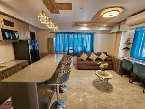 a kitchen and living room with a counter and a couch at 2 Bedroom Corner in Davao City