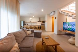 a living room with a couch and a tv at Via Tendenza Condos in Playa del Carmen
