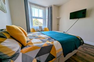 a bedroom with a bed and a television on a wall at Spacious Studio with Private Kitchen and Bathroom in Hounslow