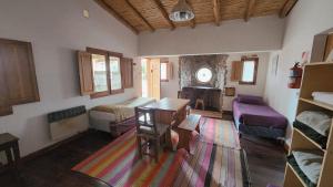 a room with two beds and a table in it at ETERNO SOL Loft Andino in Humahuaca