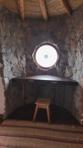 a wooden stool in a room with a window at ETERNO SOL Loft Andino in Humahuaca