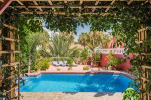 a swimming pool in a yard with a pergola at Majestic Villa by the Beach Heated Private Pool & Jacuzzi in Benalmádena