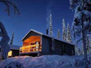 a building with lights on it in the snow at Peaceful Cabin with Hot Tub and Nature Views, Villa Lakeside Ruka in Ruka