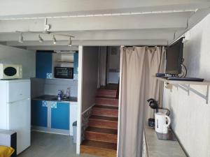a room with a staircase leading to a room with blue cabinets at Maison 2-4 personnes, vue sur le Sancy in Murat-le-Quaire