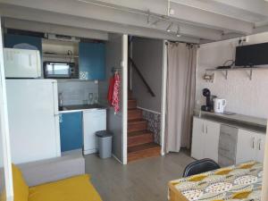 a small room with a kitchen and a living room at Maison 2-4 personnes, vue sur le Sancy in Murat-le-Quaire