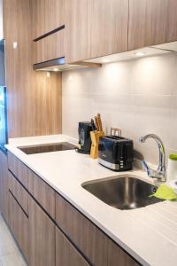 a kitchen with a sink and a microwave at Loica Host - Smart in Santiago +76 photos