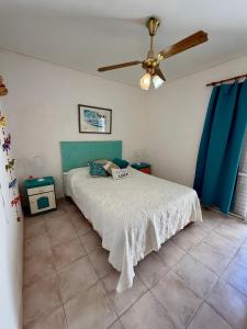 a bedroom with a bed and a ceiling fan at Magos al sur Mare in Las Grutas