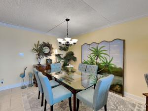a dining room with a table and blue chairs at Island Echos #3K in Fort Walton Beach