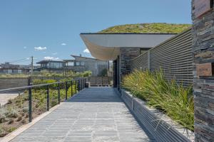 a walkway leading up to a building with a roof at Playa Vik Jose Ignacio in José Ignacio