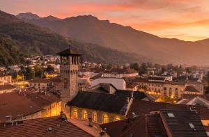 a view of a town with a clock tower at sunset at The Queens House in Bellinzona