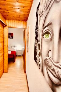 a hallway with a painting of a face on the wall at Mediterranea Apartment in Agrigento
