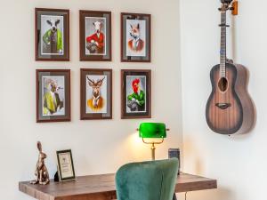 a room with a desk and a guitar on a wall at Haybale Barn in Chatton