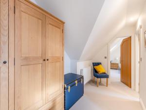 a room with a wooden closet and a blue desk at Haybale Barn in Chatton