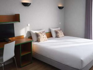 a bedroom with a bed and a desk with a computer at Aparthotel Adagio Access Paris Maisons-Alfort in Maisons-Alfort