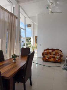 a dining room with a wooden table and a couch at Casa Baluana vive Sayulita a un paso de todo in Sayulita