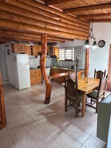 a kitchen with a wooden table and a refrigerator at Las Palomas in Trevelín