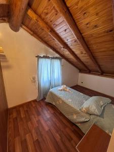 a bedroom with a bed and a wooden ceiling at Las Palomas in Trevelín