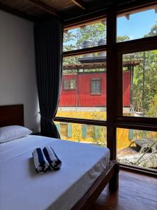 a bedroom with a bed and a large window at Barren House in Hiriketiya +70 photos