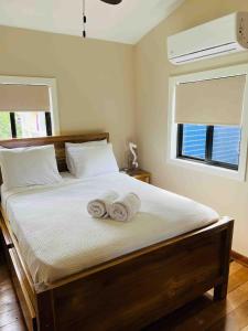 a bedroom with a bed with two towels on it at The Flying Toucan Beach Rentals in Placencia