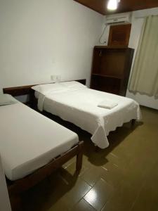 zwei Betten in einem Zimmer mit weißer Bettwäsche in der Unterkunft Hotel Malacarne in Teixeira de Freitas + 33 Fotos