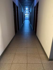 ein leerer Flur mit Türen und Fliesenboden in der Unterkunft Hotel Malacarne in Teixeira de Freitas