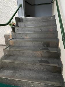 eine Betontreppe mit grünem Geländer in der Unterkunft Hotel Malacarne in Teixeira de Freitas