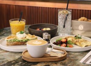 a table topped with plates of food and a cup of coffee at Hotel Savorsky in Jihlava