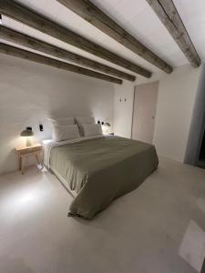 a bedroom with a large bed in a white room at Casa do Capitão in Monte Trigo