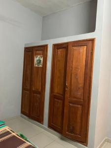 two wooden doors in a corner of a room at VOYALUX BENIN Appartement in Cotonou