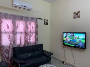 a living room with a couch and a flat screen tv at VOYALUX BENIN Appartement in Cotonou