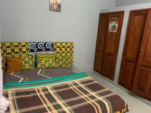 a bedroom with a bed with a rug on the floor at VOYALUX BENIN Appartement in Cotonou