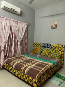 a bedroom with a bed in a room with a window at VOYALUX BENIN Appartement in Cotonou