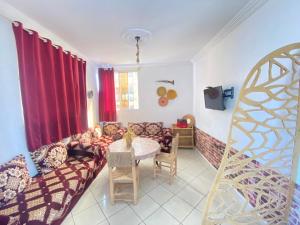 a living room with a couch and a table at Red Carpet Surf Camp Tamraght , Sea & Mountain View, Surf Lessons Available in Tamraght Ouzdar