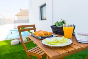 a table with a plate of food and a glass of orange juice at Sport Hotel A Seleção in Setúbal
