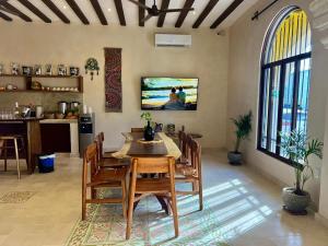 a dining room with a table and chairs and a tv at Casa Lucia Valladolid in Valladolid