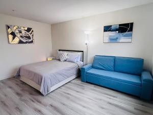 a bedroom with a bed and a blue couch at Stylish & Fully Renovated Home! in Oxnard