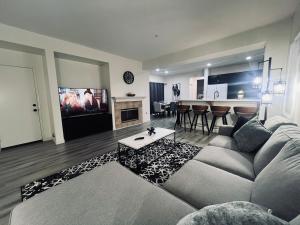 a living room with a couch and a table and a tv at Stylish & Fully Renovated Home! in Oxnard