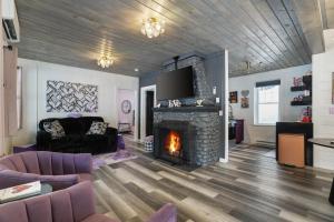 a living room with a fireplace and purple furniture at Lakefront Couples Retreat in the Poconos in Saylorsburg