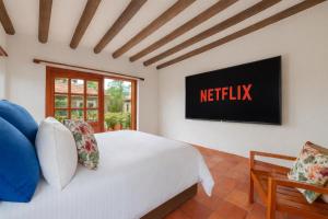 a bedroom with a bed and a tv on the wall at Casa Fiorella in Villa de Leyva
