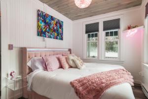 a bedroom with a white bed with pink pillows at Lakefront Couples Retreat in the Poconos in Saylorsburg