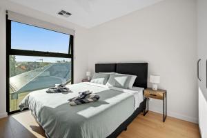 a bedroom with a large bed and a large window at Harborview Modern Apartment 8F in Victor Harbor