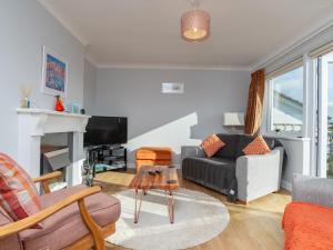 a living room with a couch and a tv at Bosula in Fowey