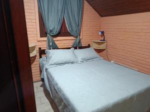 a bedroom with a bed and a window with blue curtains at Cabañas Brisa's in Santa Vitória do Palmar +29 photos