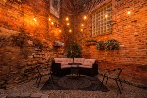 a brick wall with a couch and two chairs and a table at Velvet Haus Downtown 3rd Floor Deck Backyard in Cincinnati
