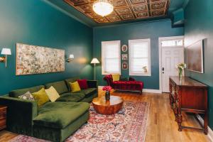 a living room with a green couch and a table at Velvet Haus Downtown 3rd Floor Deck Backyard in Cincinnati