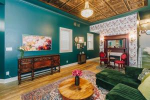 a living room with a green couch and a table at Velvet Haus Downtown 3rd Floor Deck Backyard in Cincinnati