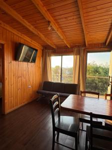 a living room with a table and a couch at Cabañas Mc Chelo Pelluhue in Pelluhue