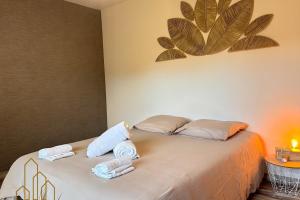 a bedroom with a bed with towels on it at L'instant Douceur in Riorges