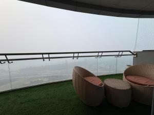 a balcony with two chairs and a view of an airport at Spira staycation in New Delhi